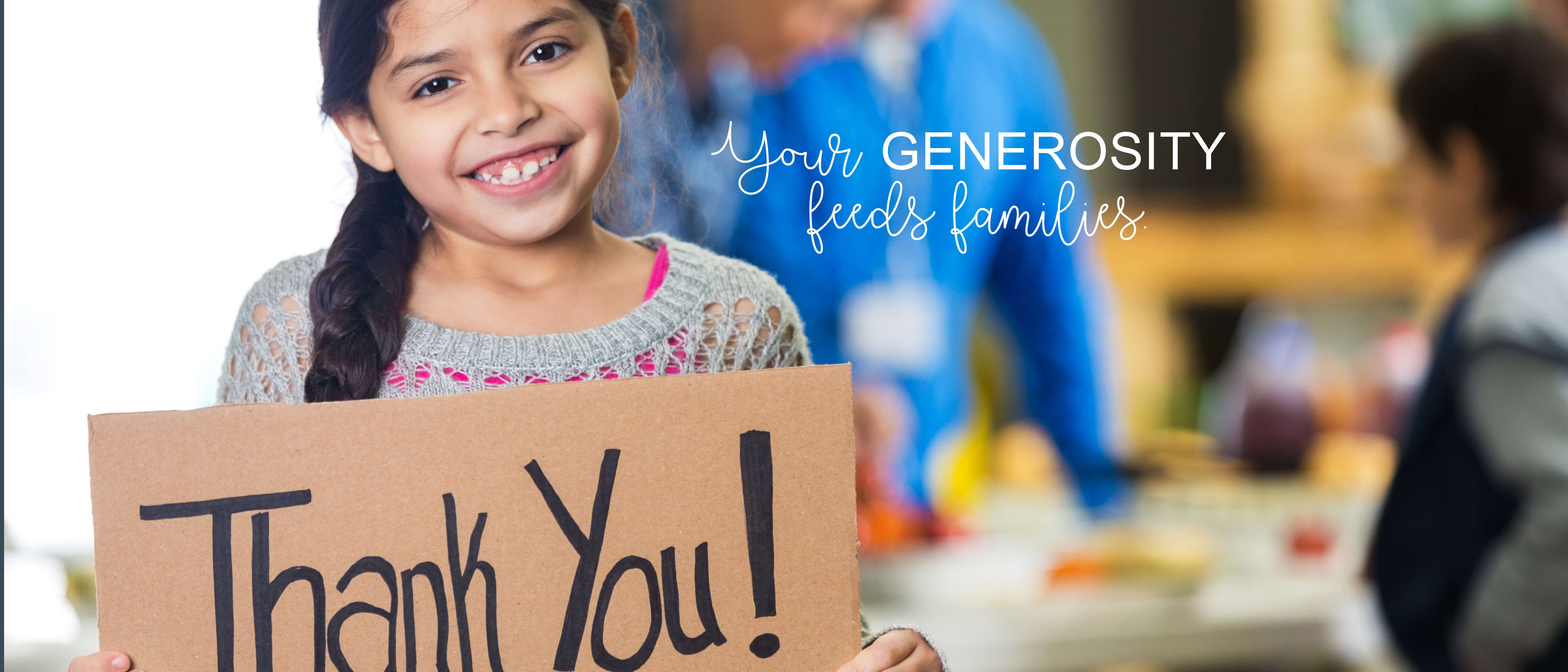 A Girl holding THANK YOU sign at food bank