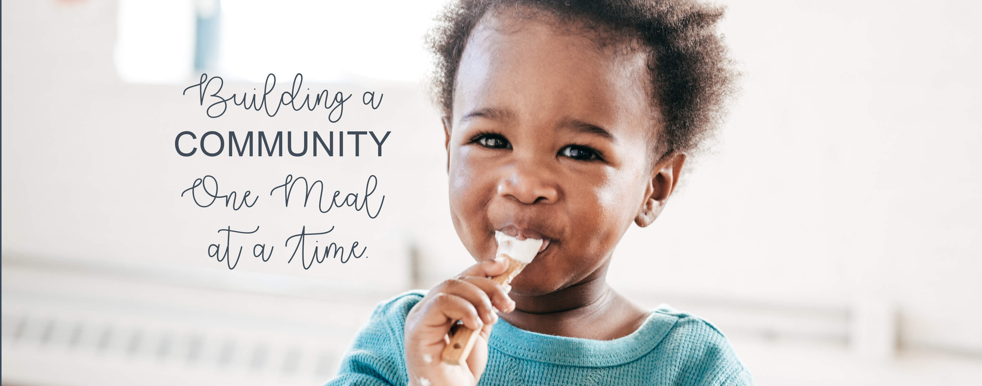 Happy little boy eating yogurt for breakfast.